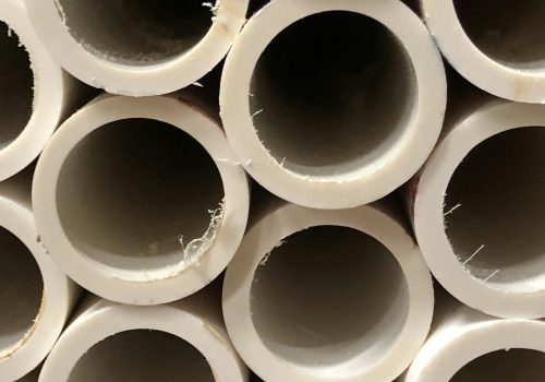 A wall of large white pvc pipes at warehouse store