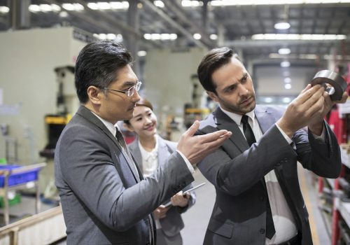 Business people checking machine parts in the factory